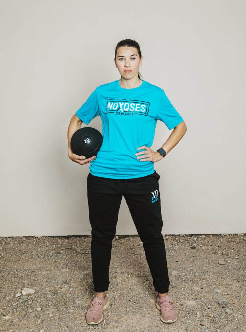 Person holding medicine ball, wearing sportswear.
