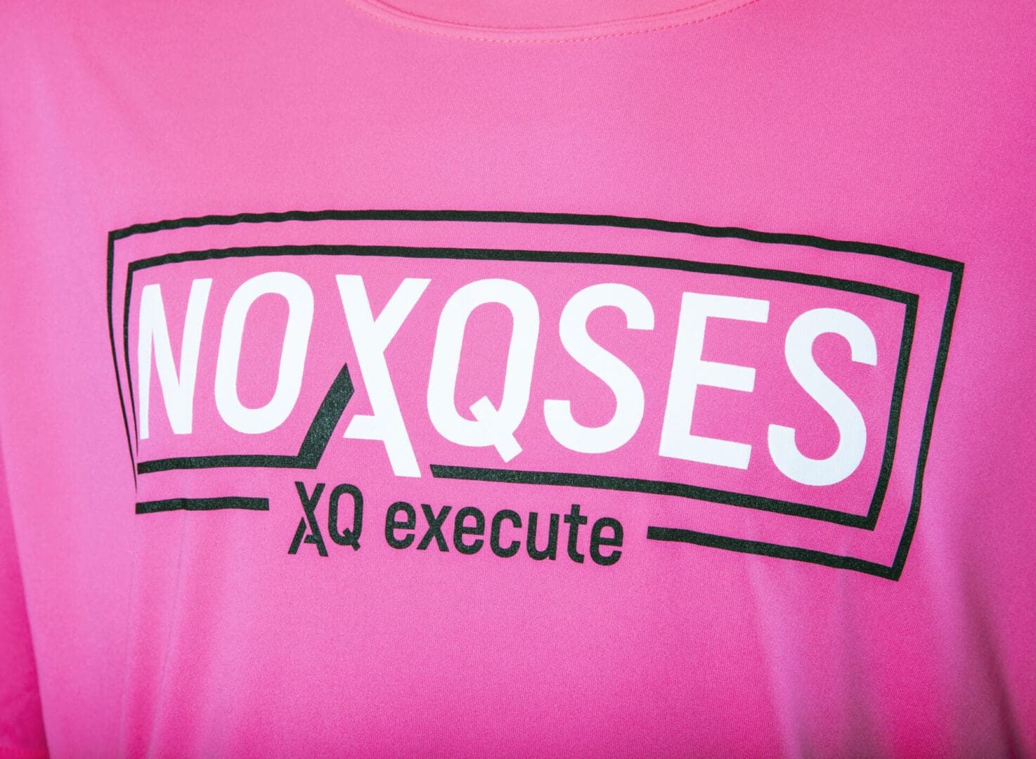 Pink shirt with "NOXQSES XQ execute" text.