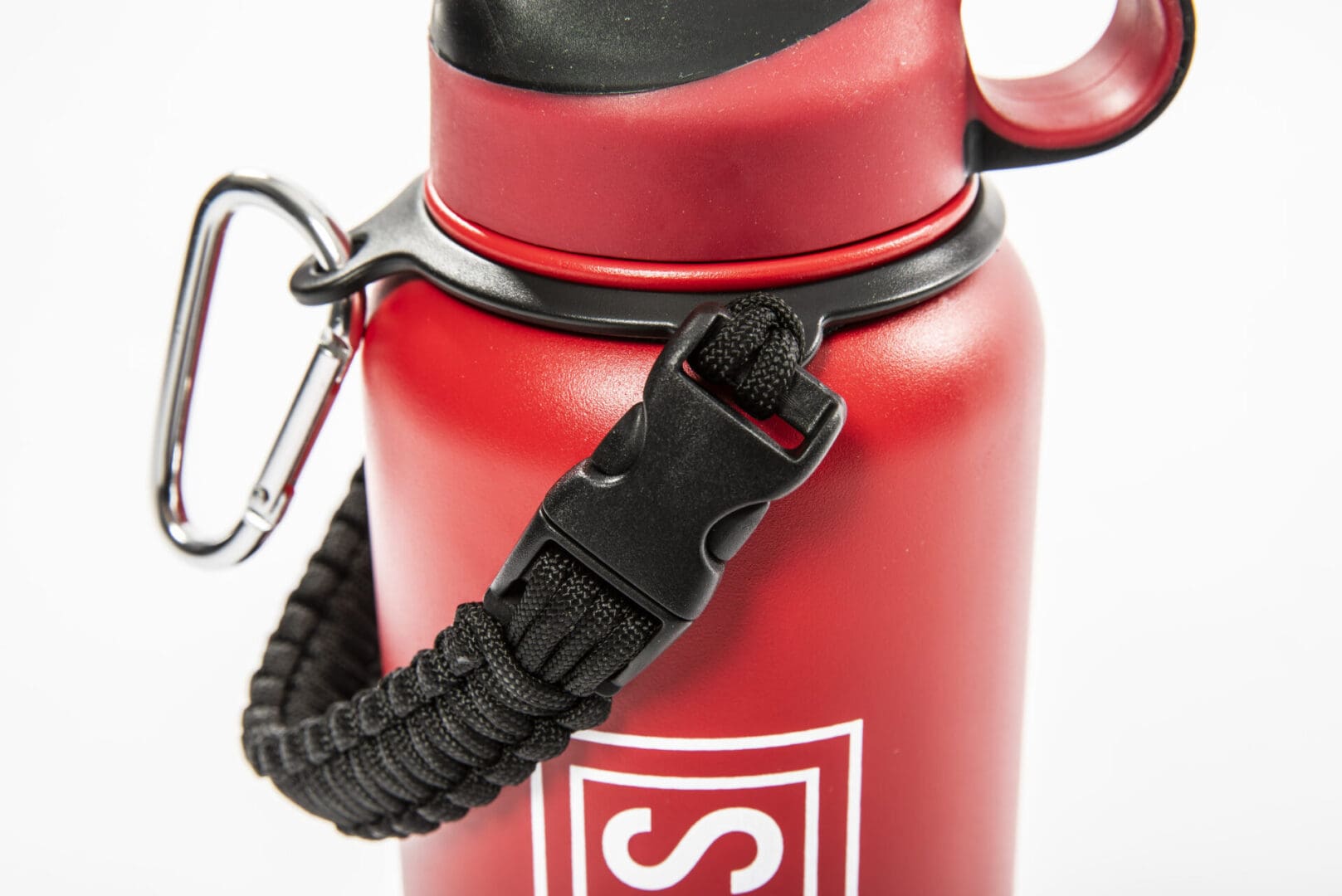 Red water bottle with carabiner and strap.