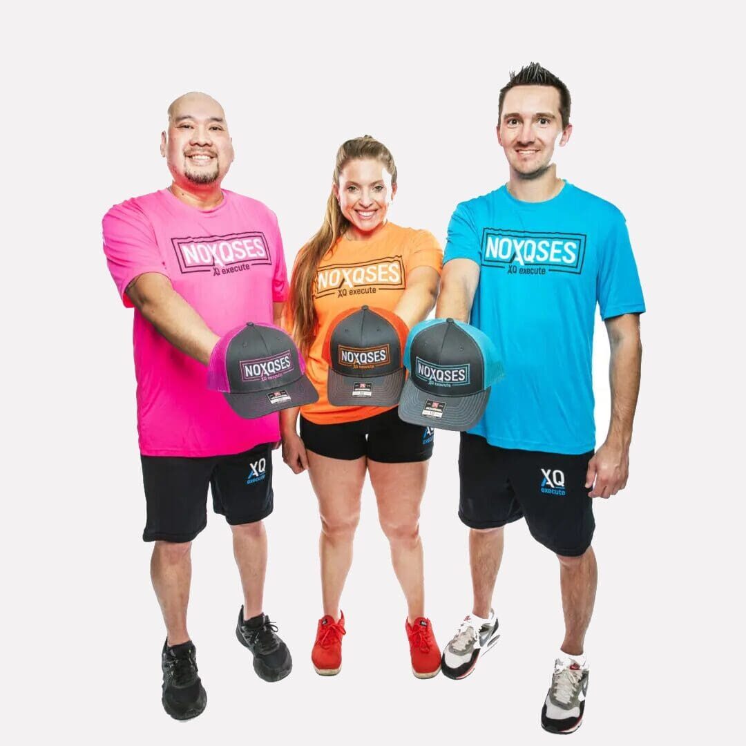 Three people holding branded hats, smiling.